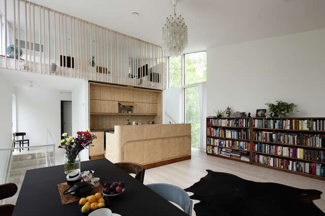Interior with wooden kitchen area, book shelf and entrance and view to the upper floor