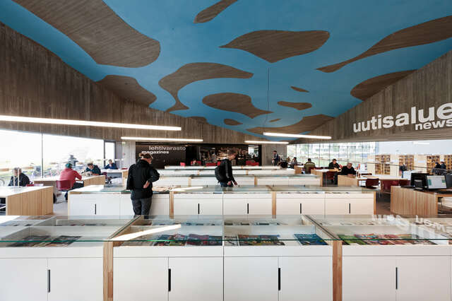 White drawers with newspapers, concrete ceiling with a large blue motif