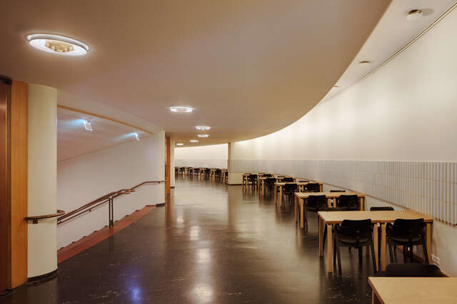 Foyer corridor passage to a staircase with tables and chairs on the right