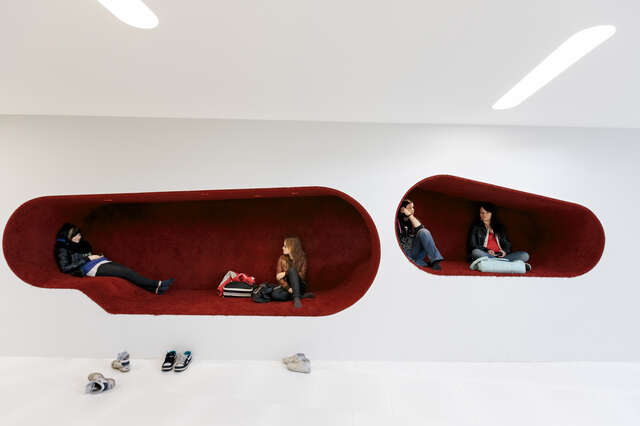 Dark red reading niches inside white walls