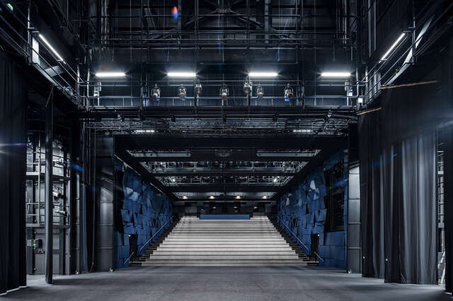 Dark room with metal structures and spotlights.