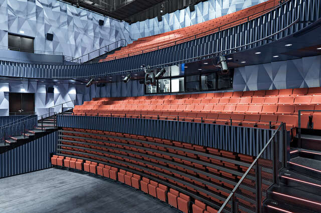 A hall with lower auditorium seats upholstered in red folded away