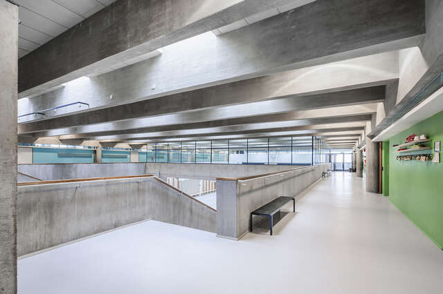 Corridor next to a staircase with concrete elements.