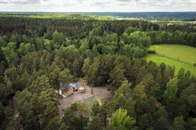 Aerial view, forested landscape with an opening in the middle: the outdoor theatre