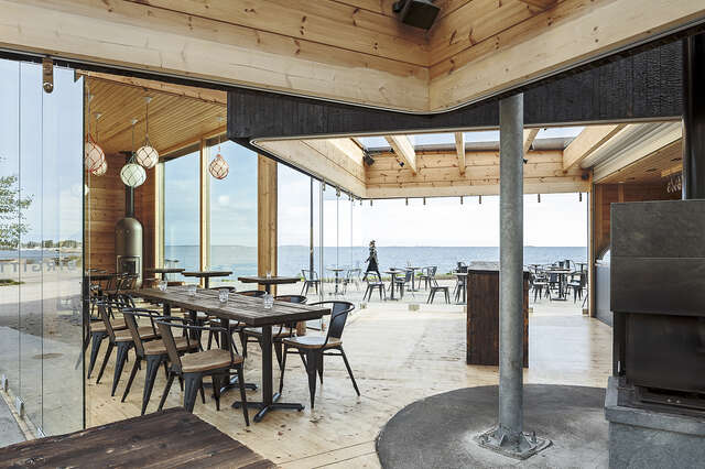 Wooden interior with a glass wall shoving an ocean view.