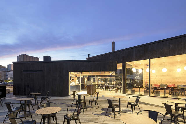Wooden cafe with a large terrace during sunset.