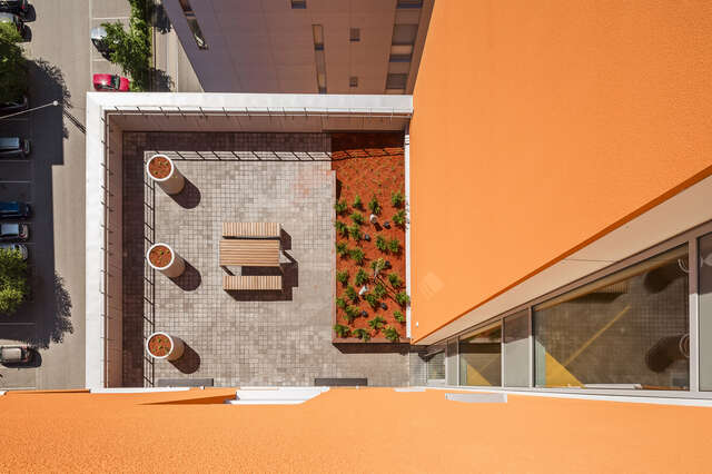 Terrace planters and a piknick table in a orange building.