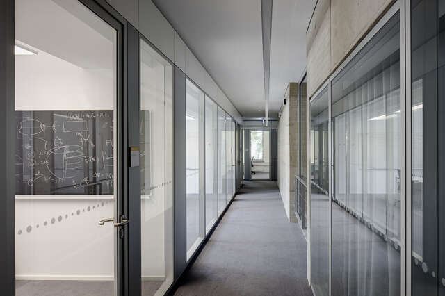 Hallway with glass walls and -doors into each room