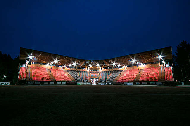 Night-time view, canopy and red stands are lit