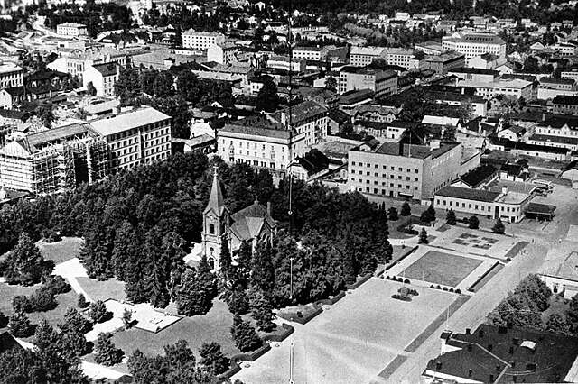 Black and white aerial picture of a church and its city surroundings.