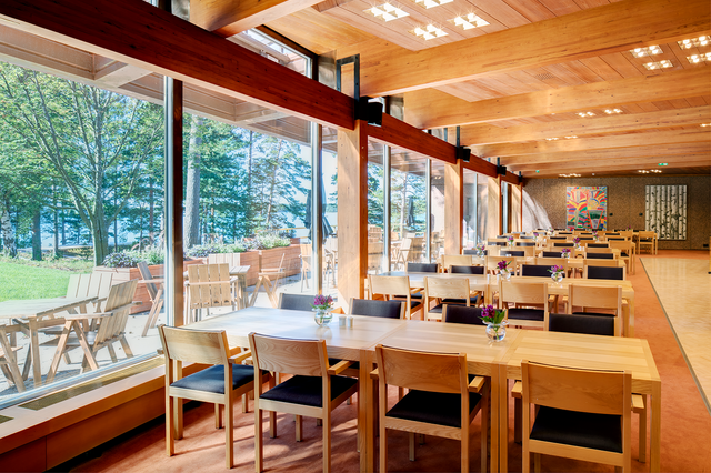 View of large dining area with multiple tables and chairs, view of outside through window