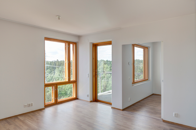 Windows of an apartment with white walls and wood floor.