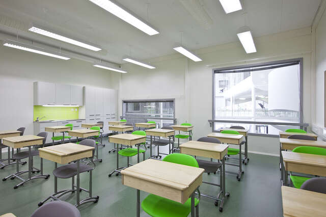 White classroom with modern furniture and single desks.