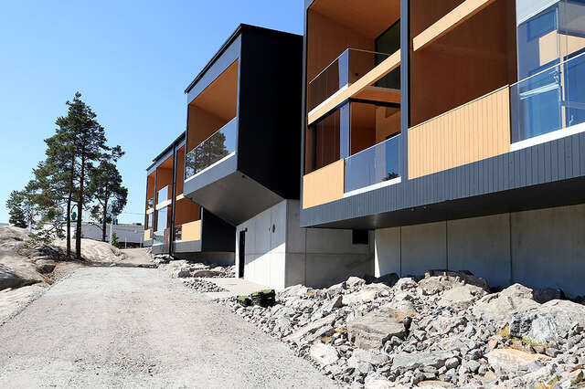 Row of balconies with asphalt road in foreground.
