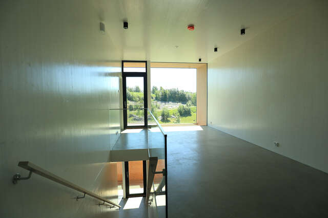 Hallway with window in the back. Stairs leading down in front.