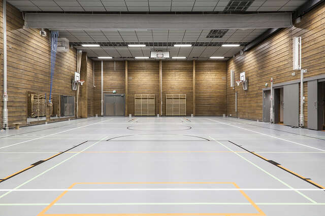 School gymnasium with dark wooden walls.