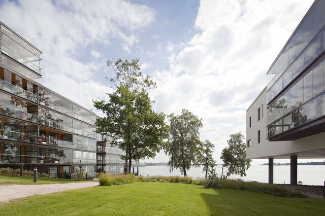 View towards the sea, modern buildings with glass balconies on both sides.