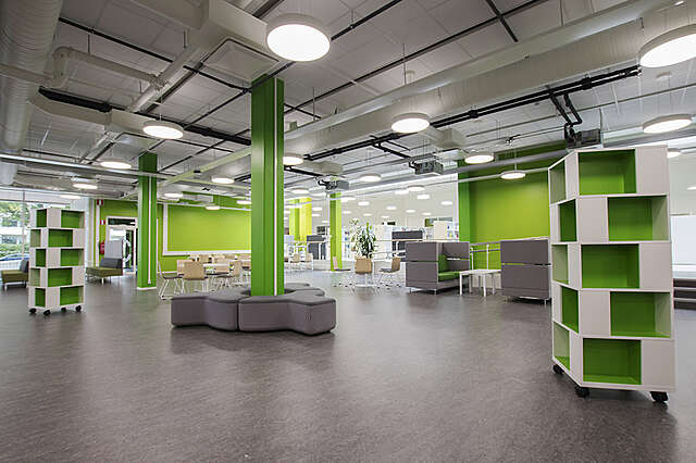 Interior with flexible seating and green details.