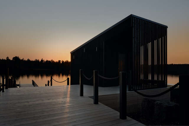 View of pier at sunset with dark wooden structure in the middle.
