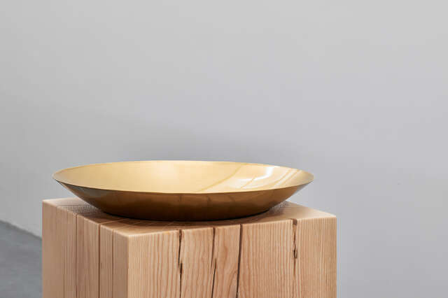Low metallic dish on a top of a wooden cube