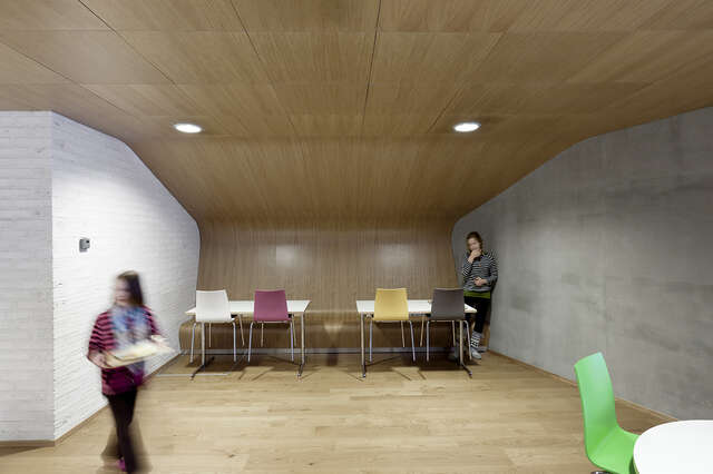 Sitting area with a curved wooden ceiling above it.