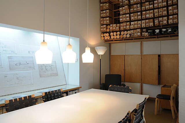 Meeting room with a large tables and boxes drawings lined up on the back wall.