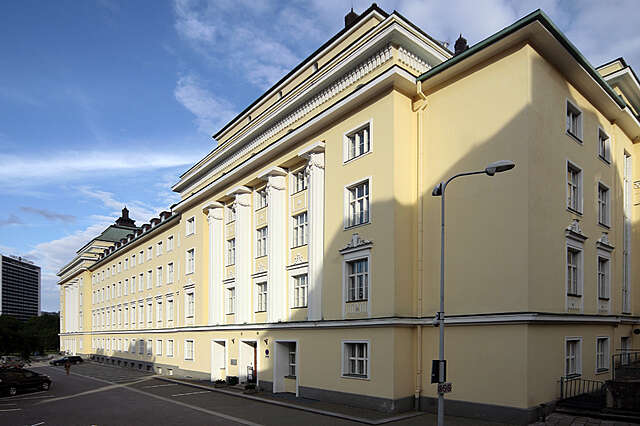 Yellow multiple storey building with white structural elements and decorations.