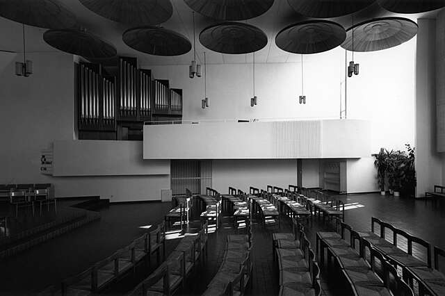 Church interior with circular acoustic reflectors at the ceiling.