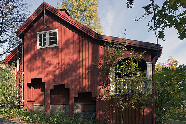 Red timber house with white window details.