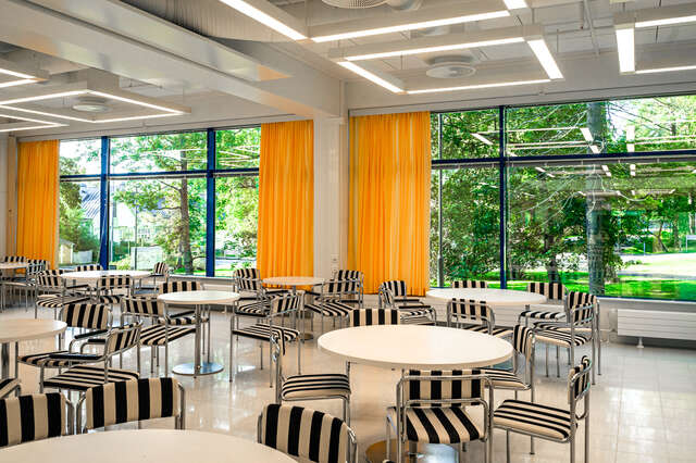 Lounge room with black-and-white striped chairs and yellow curtains.