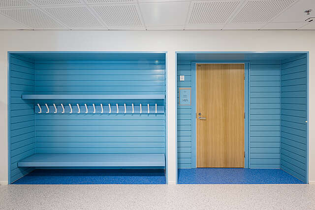 WHite hallway with blue painted inset wardrobe and door.