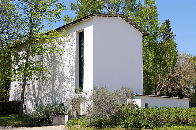 White chapel with a tall and narrow window and a gable roof.