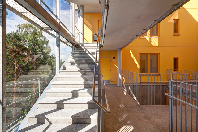 Stairs and a yellow wall. The window is on the left side of the photo.