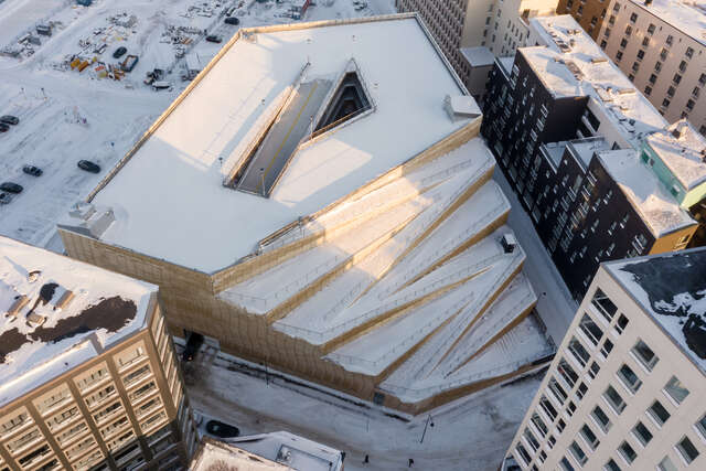 A large wooden structure in an urban area covered in snow.