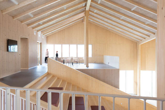 A large indoor space with a wooden staircase leading down.