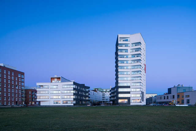 Multiple storey apartment building with no straight lines, black and white plastered walls and long balconies at the sides.