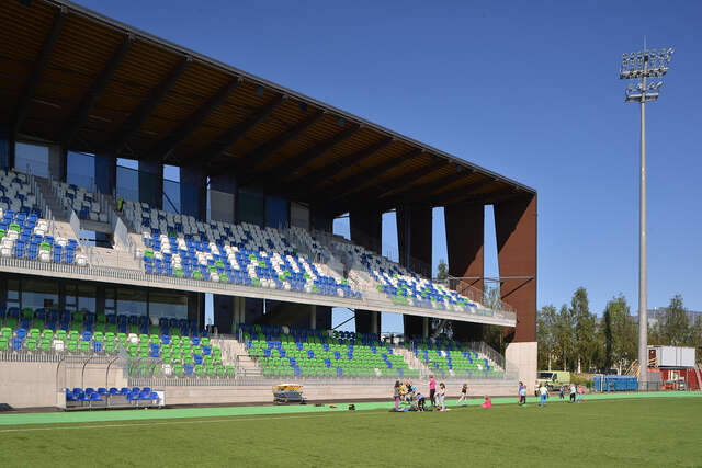 Outdoor stadium with two storeys of seats for the audience.