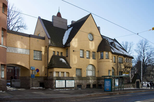 Yellow hospital facade with a stone base.