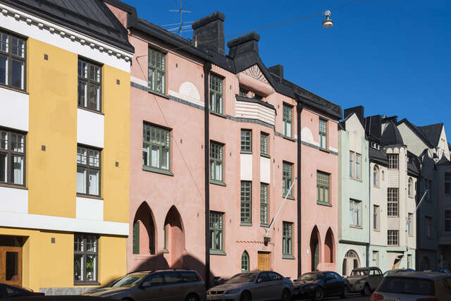 Colorful multiple floor houses with green grid windows.