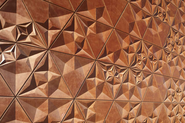 Triangular concrete elements of the façade resemble the shape of an origami.