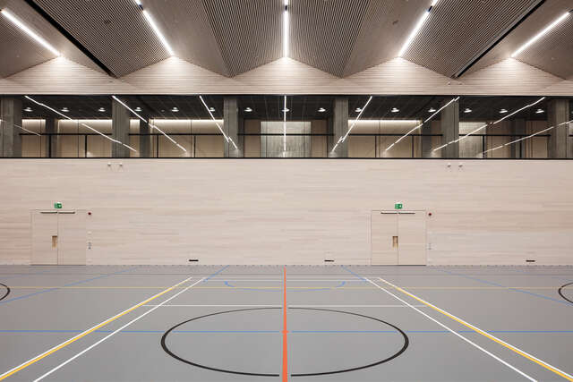 Inside a sports hall, gray floor, warm-coloured concrete