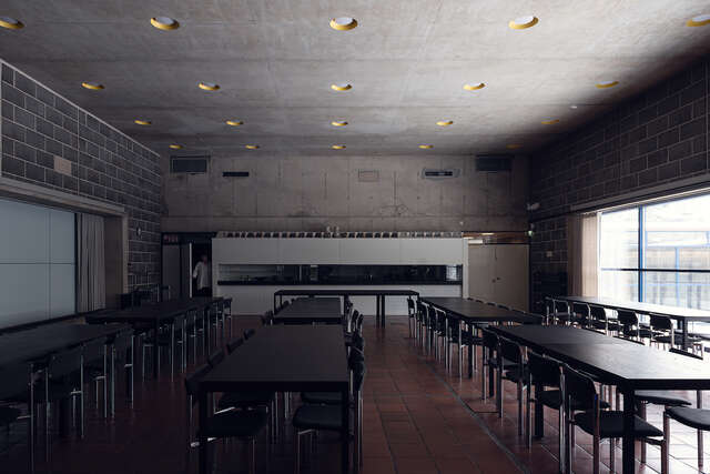 A small, dark room inside a stone structure with multiple tables and chairs.