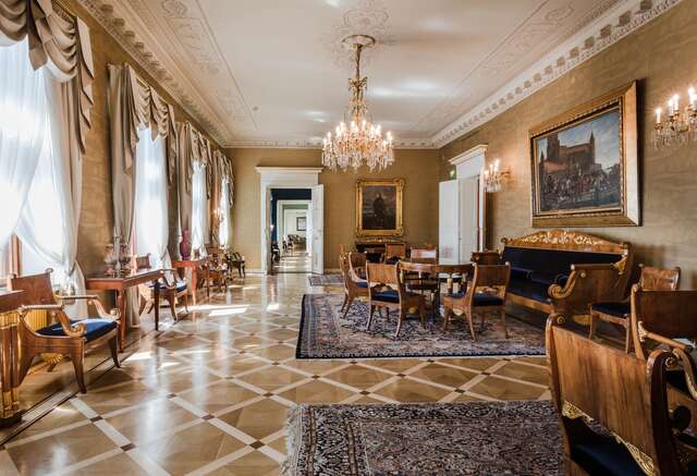 Sitting room with intricate parquet details, massive wood seating arrangements and a rich ambiance.