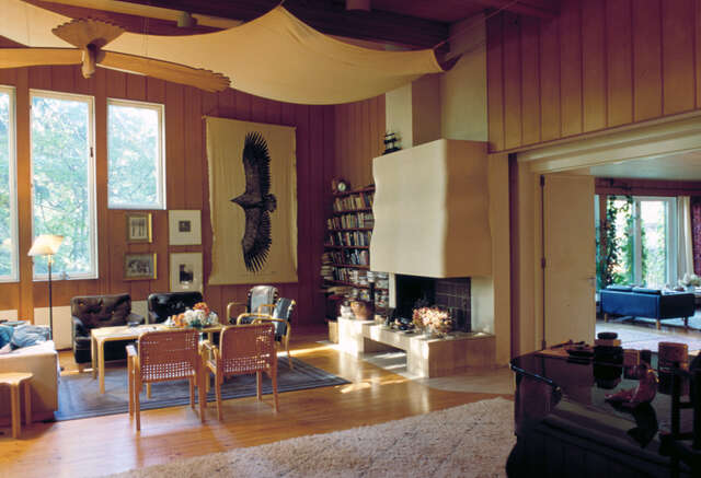 Wooden-paneled walls, sitting area and bellied acoustic ‘sail’ in the ceiling