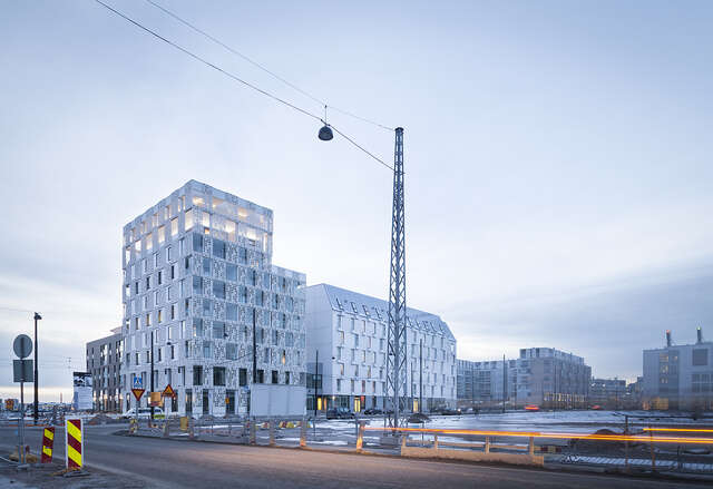 White apartment building exterior with metallic grid details.