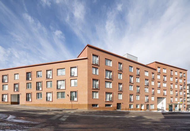 Red-brick facade with different sized and shaped windows.