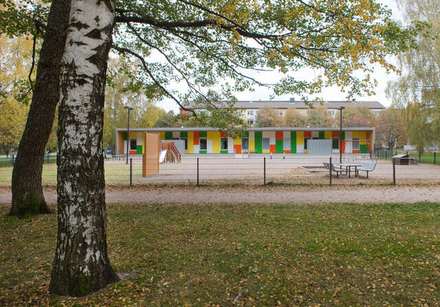 In a park surrounding, a flat roofed colourful building