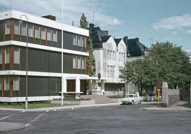 Gray, brown and white building facade with steps to the entrance.