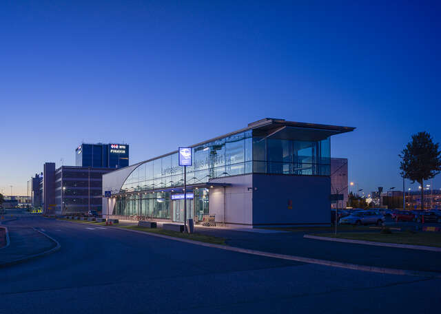 Rectangular building with large glass walls during the sunset.