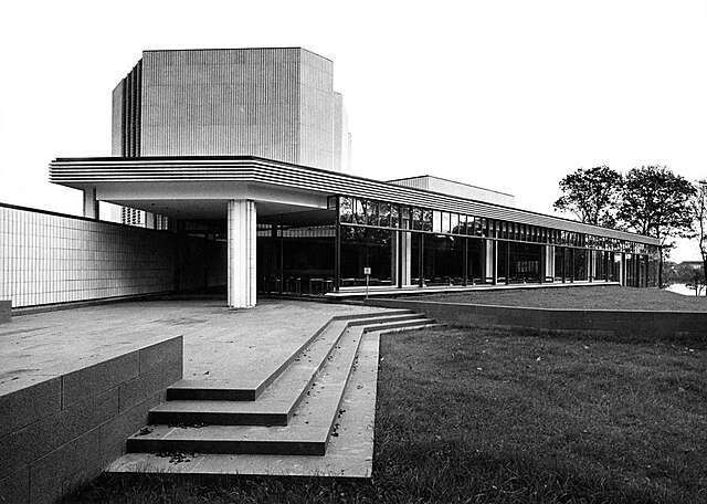 Black and white picture if the glass and tile facade of the building.